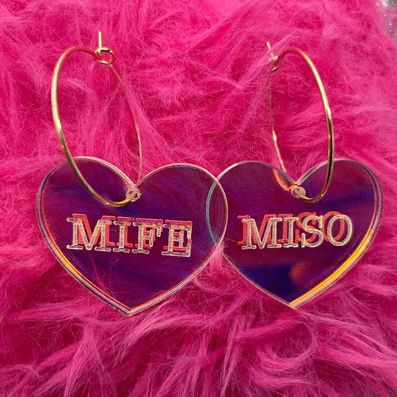 Mife and Miso earrings against a pink fuzzy background